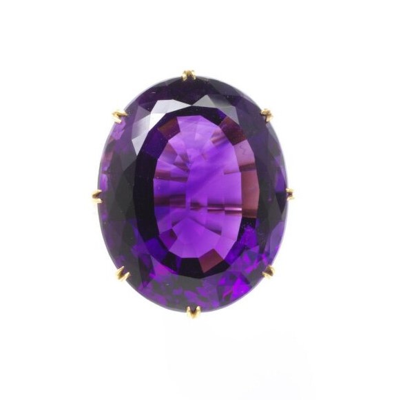 Oval faceted amethyst set in a simple gold claw setting.